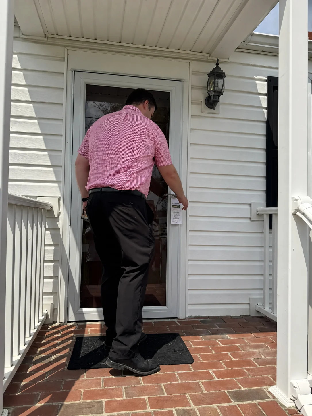 A Grace church member leaves a Gospel tract at a neighborhood door