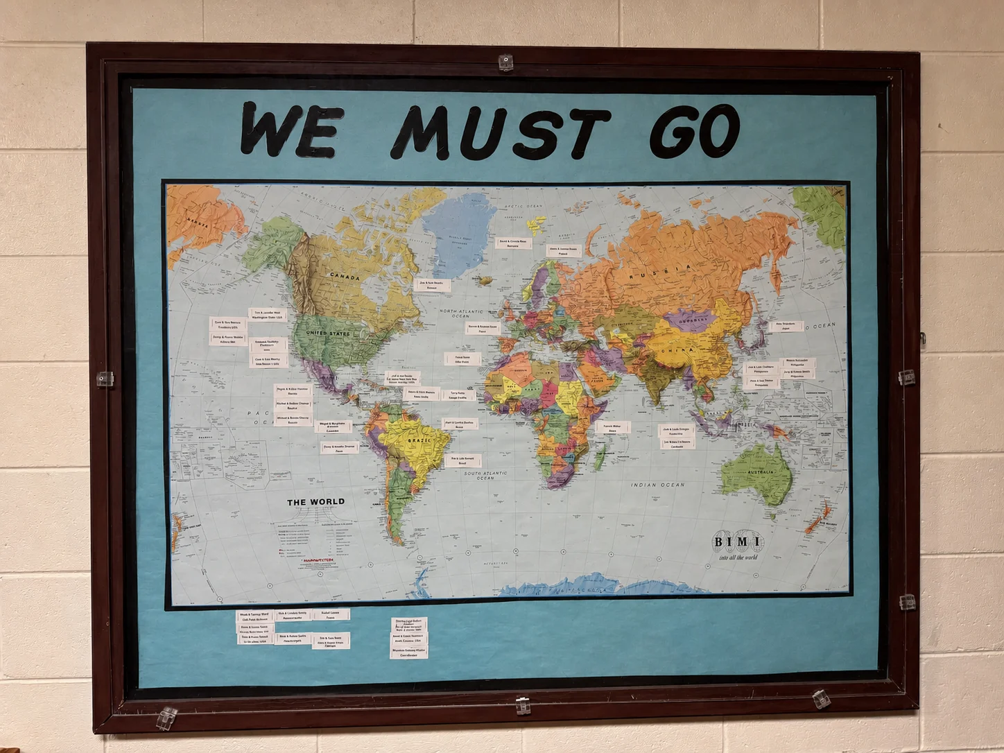 Grace Baptist Church’s framed world missions map beneath the words We Must Go